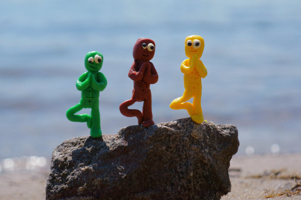 一个摆着瑜伽姿势的玩具僵尸在海边冥想。图片下载