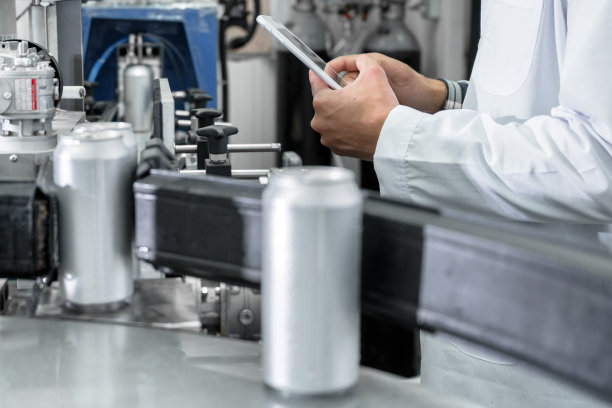 饮料厂工人用平板电脑检查生产线。高质量的摄影图片下载