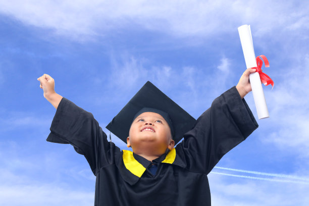 一名亚洲幼儿园男孩穿着简单自制的学校毕业服感到高兴和兴奋的肖像图片下载