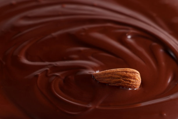 杏仁被融化的巧克力淹没了。巧克力的背景。有选择性的重点图片下载