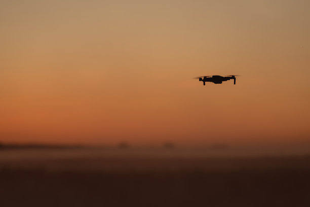一架四轴飞行器在夕阳的天空中飞行图片下载