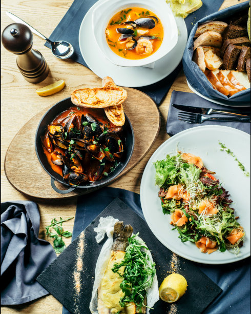 餐桌上有各种海鲜和沙拉。家庭度假表。一套不同的美味佳肴放在桌上俯视图片下载