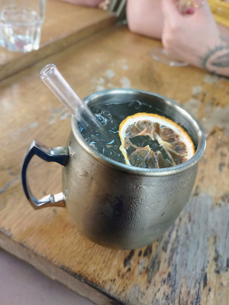 一张装满冷饮的金属杯的照片，上面有冰块，漂浮着一片柠檬图片下载