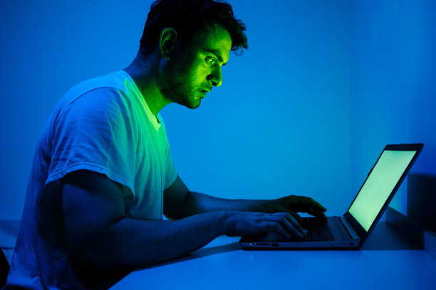 一个年轻人正在笔记本电脑前工作图片下载