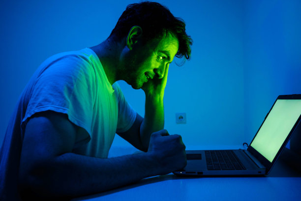 一个年轻人正在笔记本电脑前工作图片下载