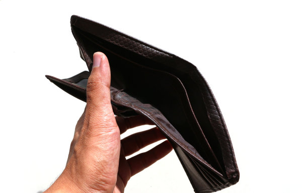 一只手拿着一个空钱包。没有钱的照片插图。图片下载