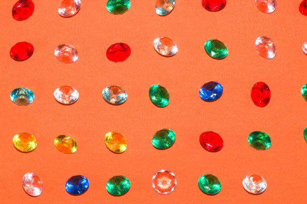 彩色假宝石在橙色背景，最小的概念，创造性的夏季设计图片下载