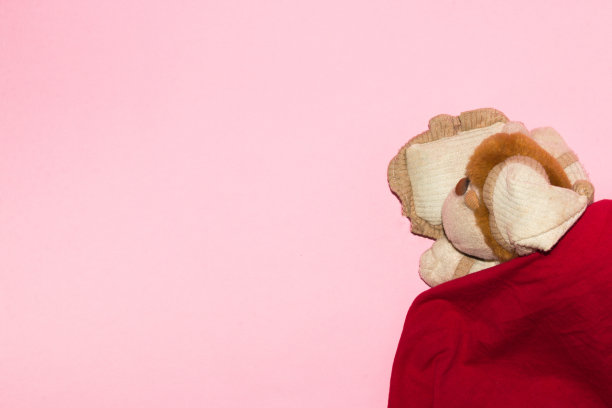 可爱的小猴子睡在毯子里，粉红色的壁纸旁边放着小猴子的copy和产品空间，创意十足的艺术设计，慵懒又梦想的一天图片下载