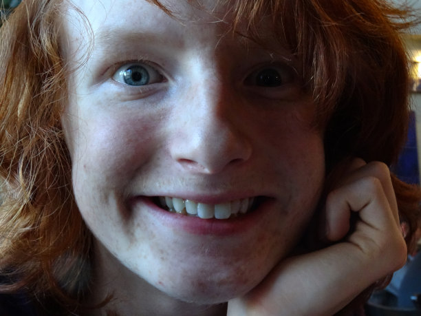全帧图像十几岁的红头发男孩鬼脸微笑直视相机图片下载