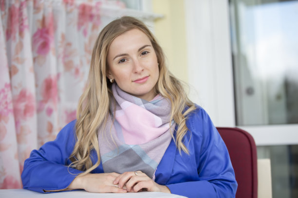 一个漂亮的年轻女人的肖像在街头咖啡馆的桌子上，穿着蓝色的夹克。图片下载