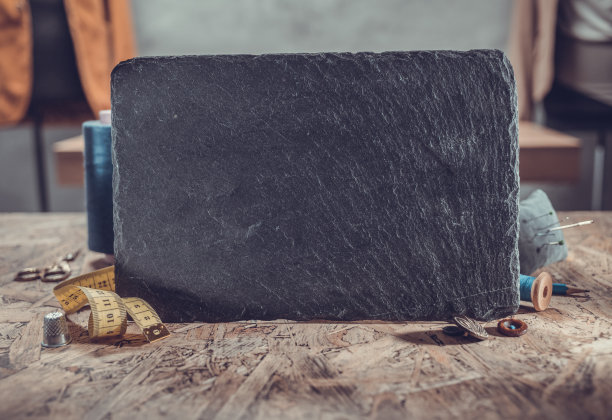 石板铭牌和木桌上的缝纫工具。概念服装工作室工作场所图片下载