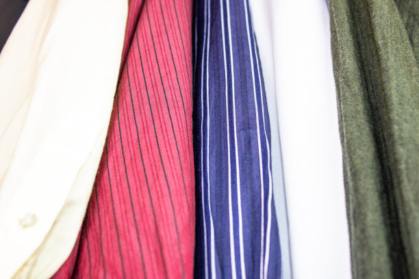 不同颜色的男士衬衫。纯棉多色底色。男士衬衫的布料特写。多色棉质面料，适合剪裁。图片下载
