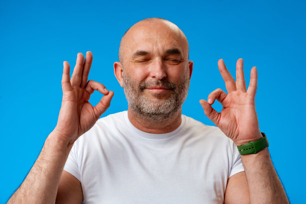 摄影棚里蓝色背景上沉思的成熟男人。图片下载