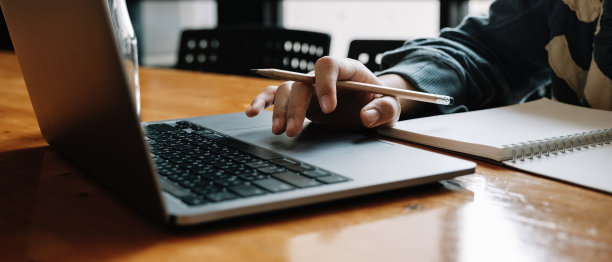 亚洲妇女使用笔记本电脑和写作的照片，制作清单，在笔记本电脑工作或学习在室内笔记本电脑-教育课程或培训，研讨会，教育在线概念图片下载