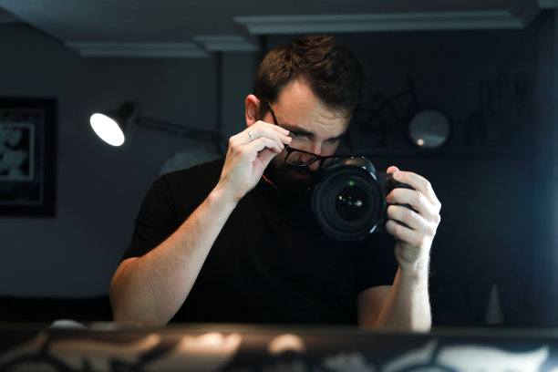 留着胡子的棕色头发帅哥，对着镜子自拍，因为今天是摄影日。图片下载