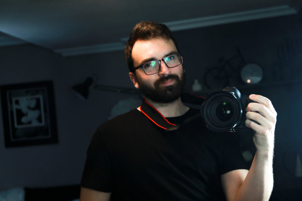 留着胡子的棕色头发帅哥，对着镜子自拍，因为今天是摄影日。图片下载