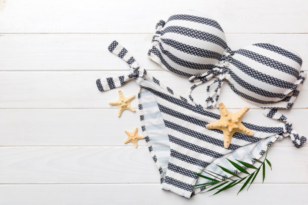 女子泳装和海滩配件平铺顶视彩色背景夏季旅行的概念。比基尼泳装，草帽和高跟鞋。复制空间俯视图图片下载