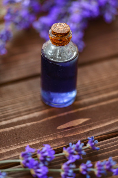 草本薰衣草油瓶与花在木制背景图片下载