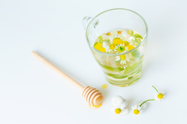 甘菊茶加蜂蜜，疗愈盛夏。草地夏季草本植物和新鲜治愈蜂蜜的概念图片下载