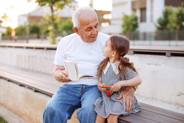爷爷在大自然中给小孙女讲故事。图片下载