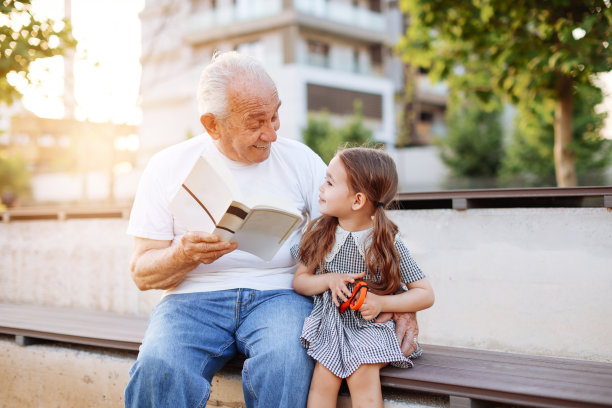 爷爷在大自然中给小孙女讲故事。图片下载