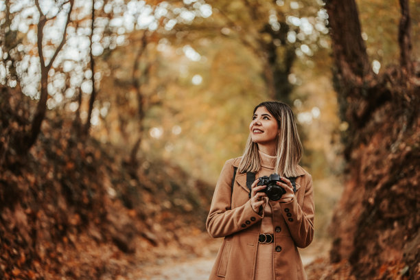 秋天在公园里拍摄的年轻女子图片下载