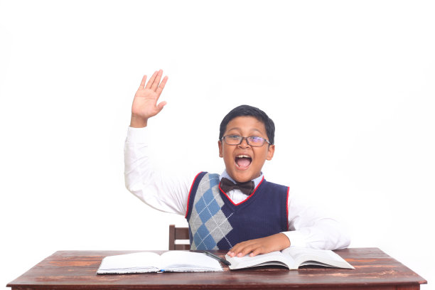 一个自信的亚洲小男孩举手回答问题图片下载