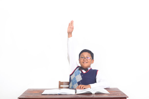 一个自信的亚洲小男孩举手回答问题图片下载