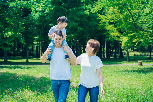 父母和孩子在公园里背背玩耍图片下载