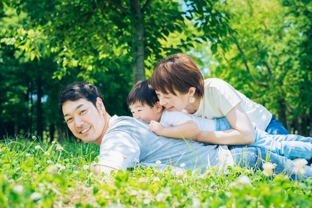 父母和孩子躺在草地上图片下载