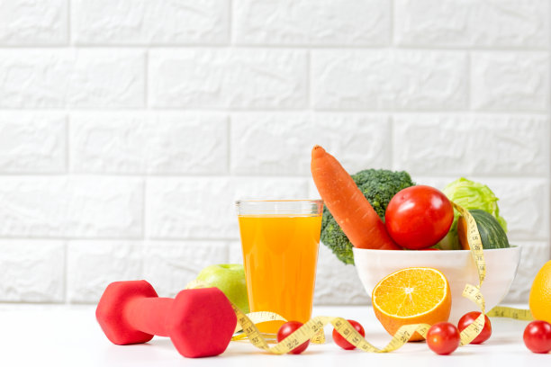 饮食健康，新鲜沙拉和蔬菜排毒，身材苗条，适合健康的生活方式，运动健身器材和橙汁，白色的背景。图片下载