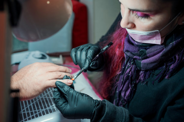 在水疗中心或美甲沙龙，美甲师在男性指甲上涂指甲油图片下载