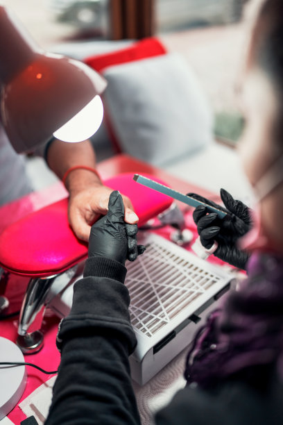 女美甲师给拉丁裔男性做美甲，修指甲，特写图片下载