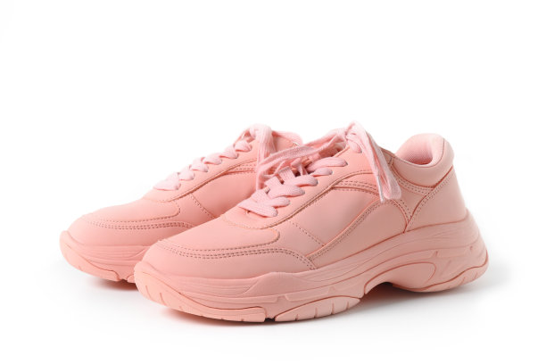 一双粉红色的女运动鞋或运动鞋孤立在白色。图片下载