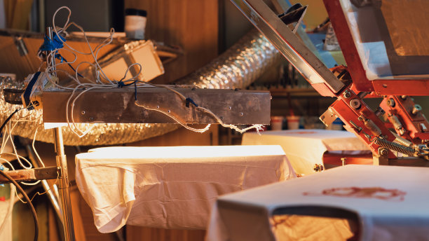 印刷检测仪器。绢印生产流程。在设计工作室用丝网法在t恤上印刷图像。选择聚焦的照片图片下载