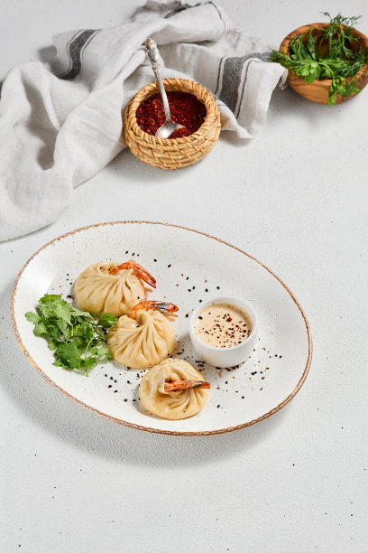 白色混凝土背景的亚洲风味蒸饺虾。陶瓷盘酱虾仁点心。虾馄饨，极简风格。亚洲海鲜饺子。图片下载