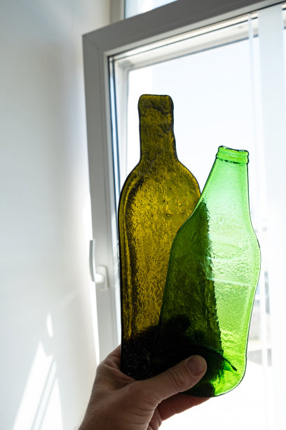 热处理后变形的葡萄酒、啤酒玻璃瓶。以熔融扁瓶为设计元素。彩色玻璃窗的装饰对象图片下载