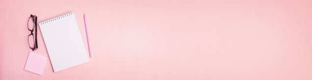 俯视图速写本，铅笔和眼镜在粉红色的背景，适合头部或横幅图片下载
