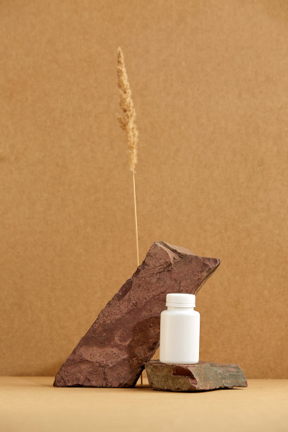 讲台上的石头在棕色的背景和小穗。石头，小穗，棕色颜色。化妆品的展示。图片下载