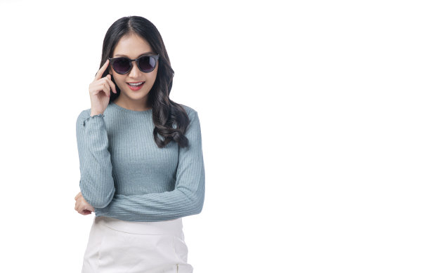 肖像时髦的亚洲女人戴着太阳镜站在白色背景。华丽积极的年轻女士握着太阳镜的手笑着拷贝空间超过孤立。夏天的生活方式的概念。图片下载