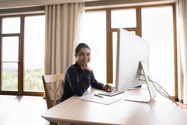头像快乐的年轻印度女性在工作场所使用电脑图片下载