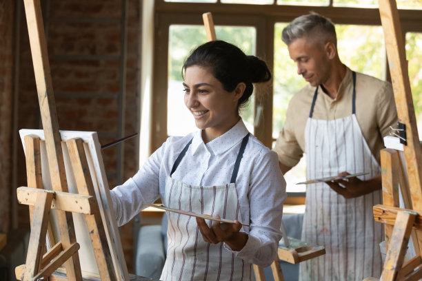 在集体艺术课上在画布上绘画的印度画家妇女图片下载