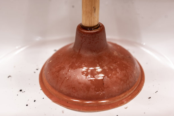 在浴室的水槽上用柱塞把头发和浮渣塞在一潭死水里。图片下载