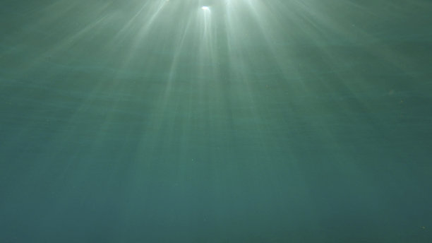 阳光穿透水面，形成美丽的光晕。日落时分，阳光洒在水面下。红海，埃及图片下载