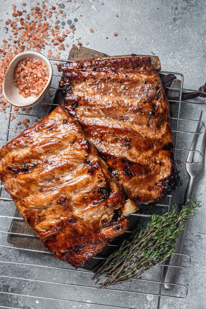 烧烤用烧烤酱在烤架上烤排骨。灰色的背景。俯视图图片下载