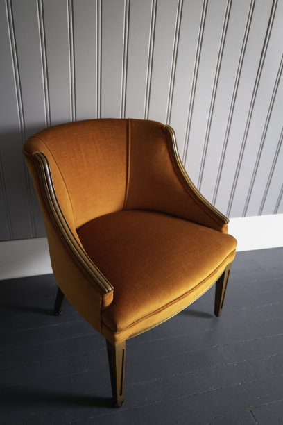 家庭室内房间家具照片的中世纪现代软垫扶手椅在白色珠板墙的橙色。图片下载