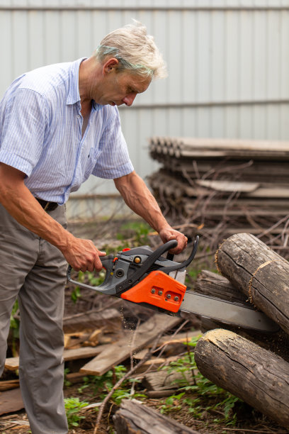 拿着链锯的人正在砍树图片下载