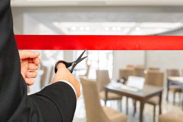 商人用剪刀剪红丝带图片下载