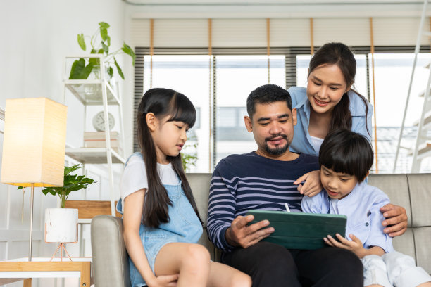 亚洲家庭使用平板电脑、笔记本电脑、手机玩游戏或看电影，在家放松的科技生活理念。图片下载