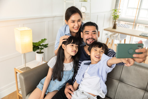 亚洲家庭使用平板电脑、笔记本电脑、手机玩游戏或看电影，在家放松的科技生活理念。图片下载